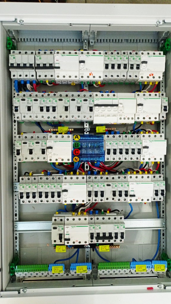 Распределительный щит Schneider Electric в белом корпусе: модульная автоматика, синий кросс-модуль фаз и N, шины PE и клеммники